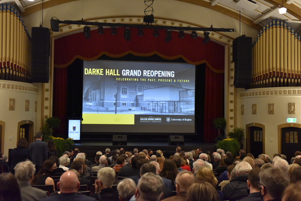 Audience members watch a video on the occasion of the Grand Reopening of Darke Hall on April 21, 2022.
