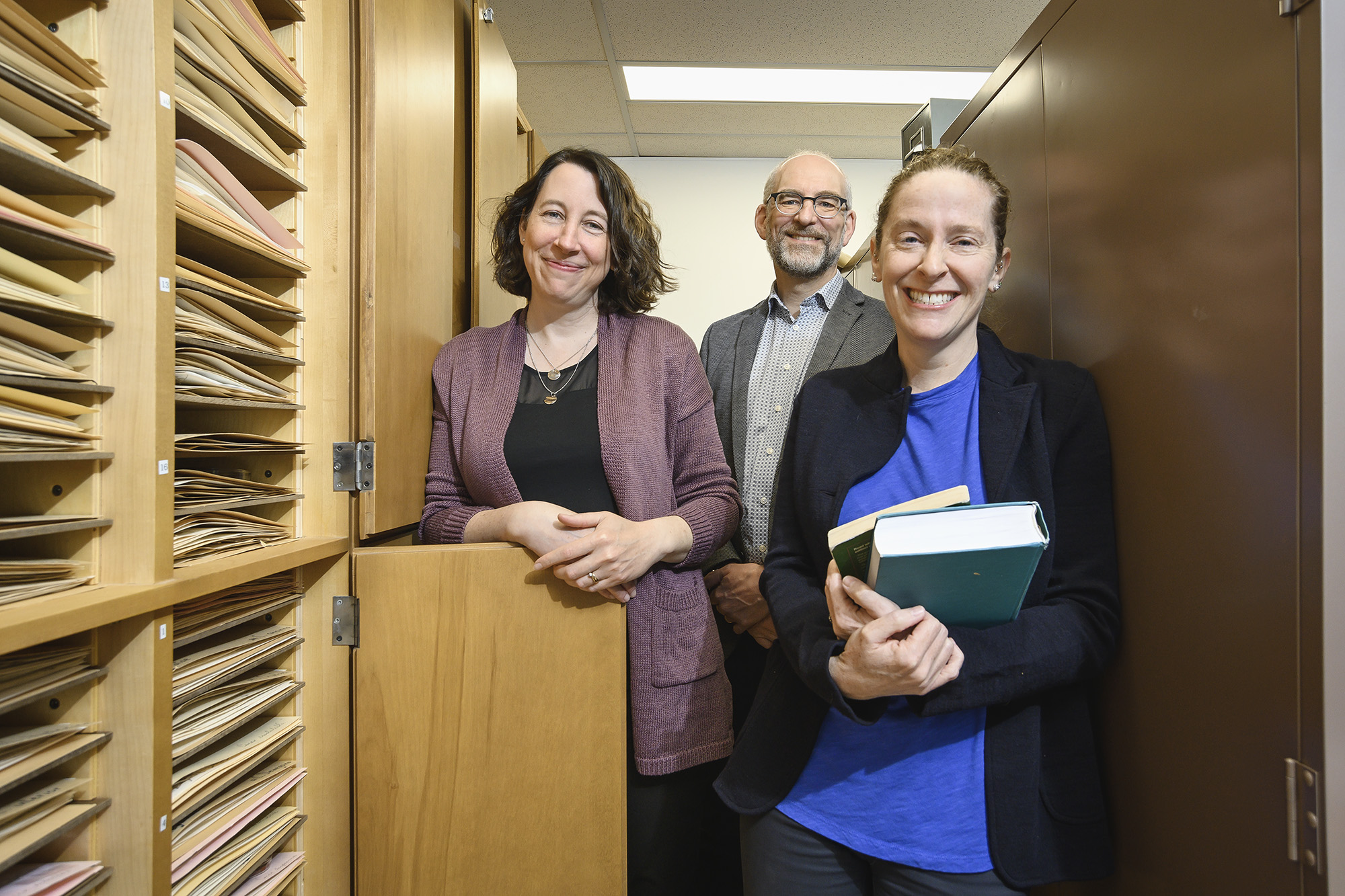 Three faculty members pose in herbarium.
