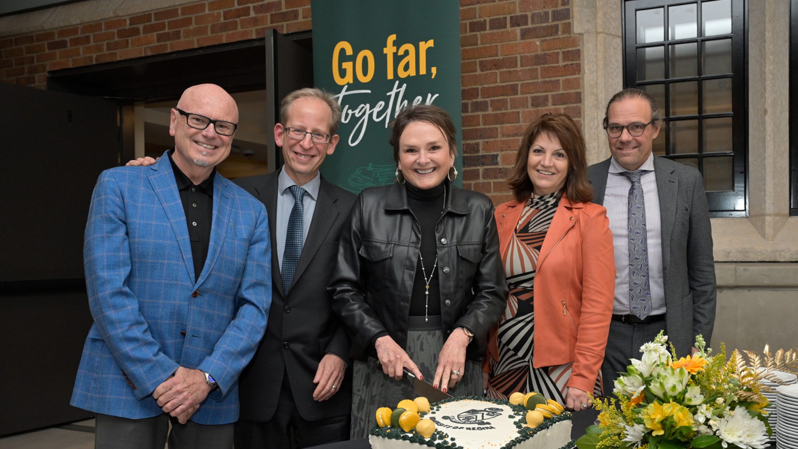 Chancellor Pam Klein surrounded by members of the University of Regina leadership team, cuts the 50th anniversary cake at the As One Who Serves 50th Anniversary Reception, October 2024.