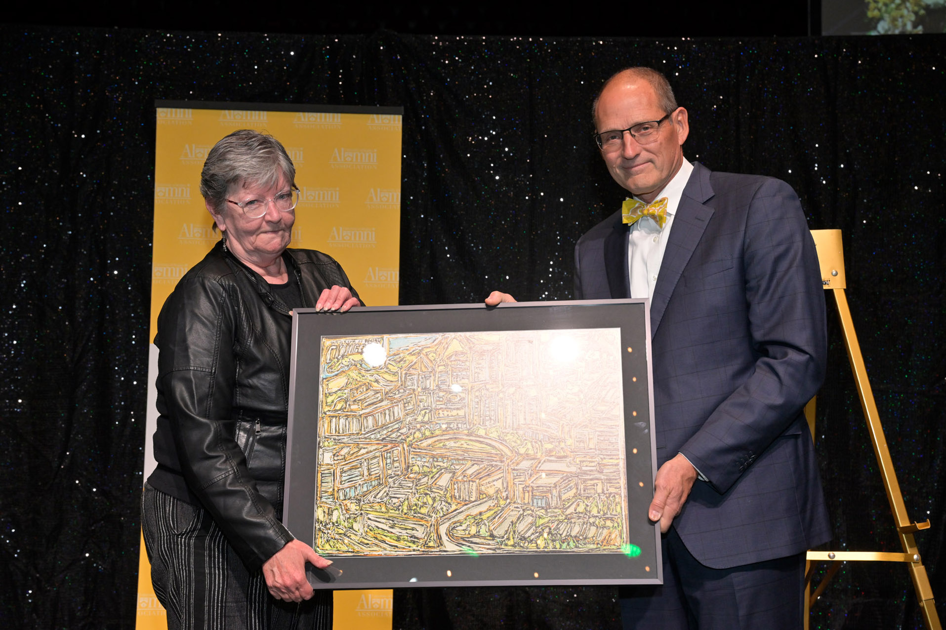 Sandi Ryan accepts award from Dr. Harold Riemer, Dean, Faculty of Kinesiology and Health Studies on behalf of inductee Jon Ryan (in absentia)