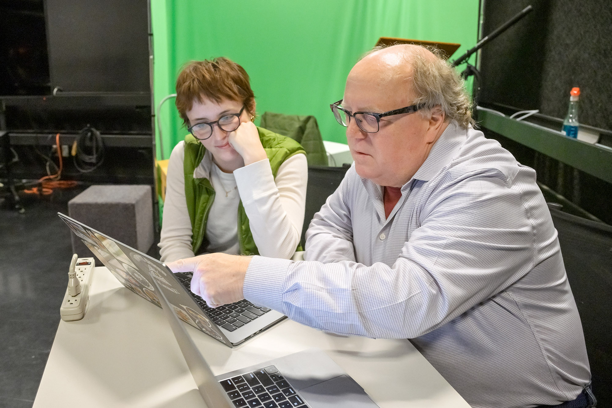 Two individuals working at laptops.