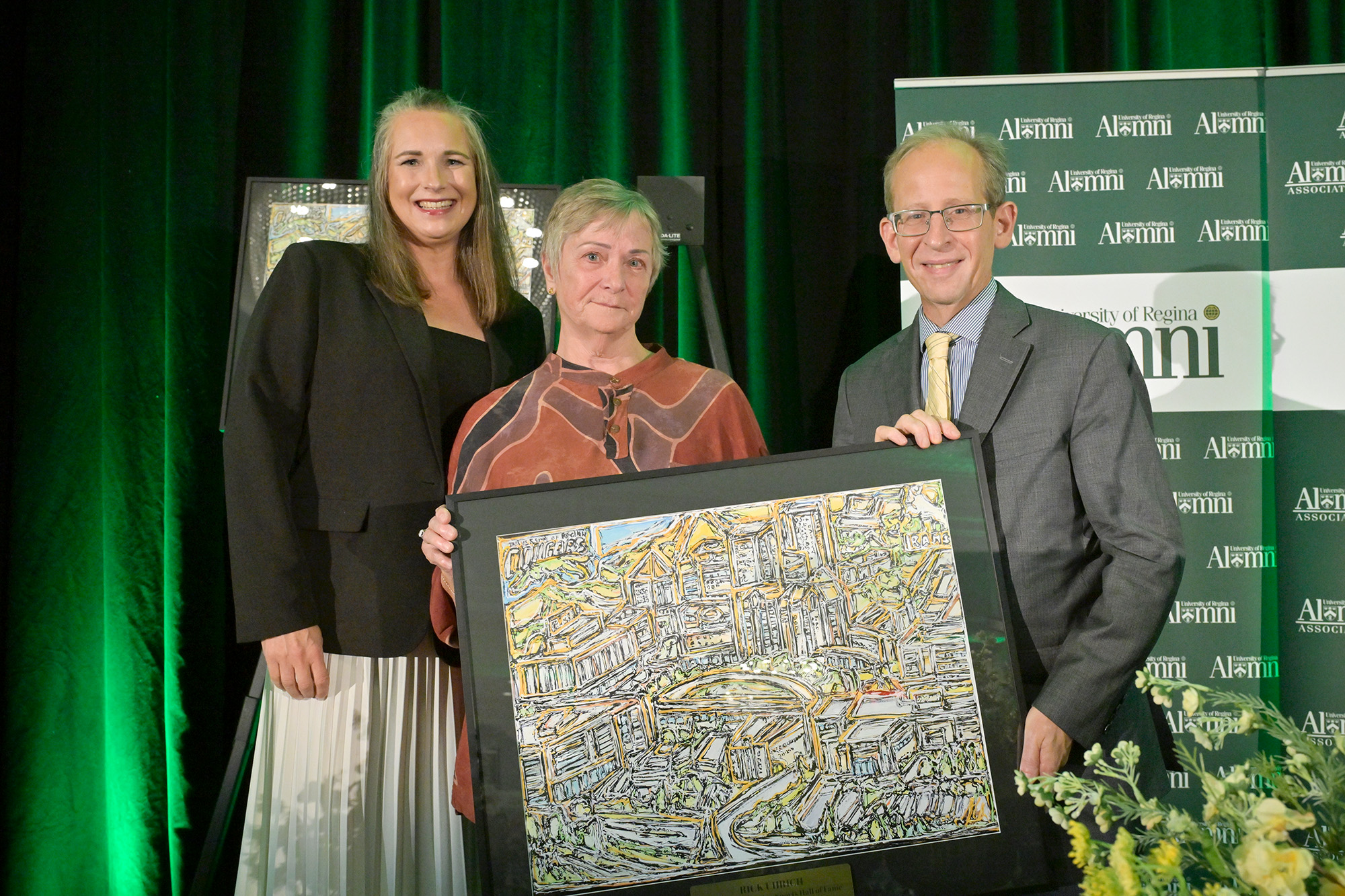 Jill Wellman accepts Rich Uhrich's posthumous induction into the Sports Hall of Fame. Pictured (l-r) Lisa Robertson, Jill Wellman, and Dr. Jeff Keshen.